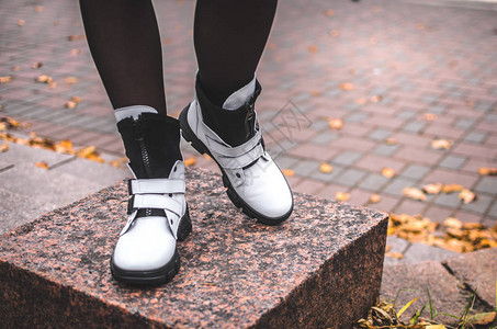 一个女孩站在花岗岩上穿着白色温暖靴子的图片