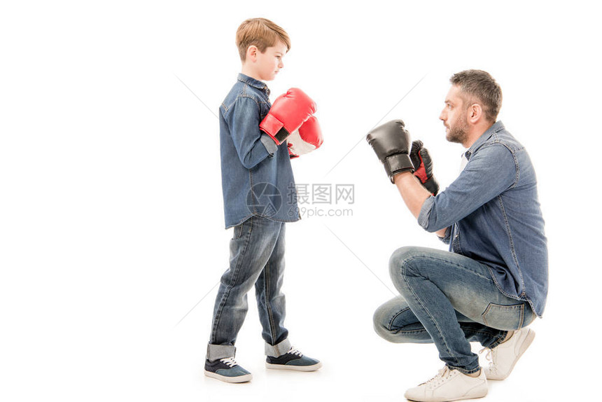 父亲和儿子戴着拳击手套与白色隔离图片