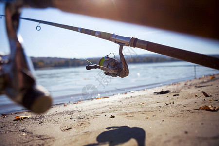 钓鱼棒在河边沙滩上图片