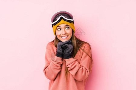 身穿孤立的滑雪衣的年轻高加索妇女举起手图片