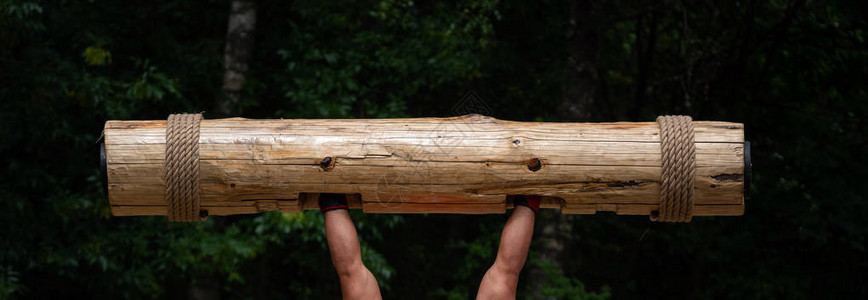 世界比赛中最强的人举起沉重的木树干的肌肉发达的手巨人图片