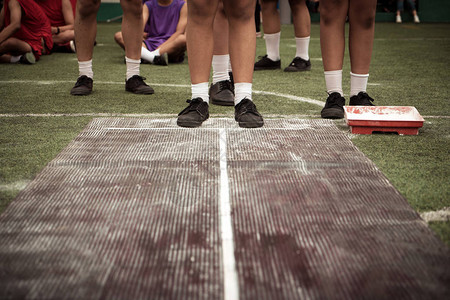 学生男孩在学校体育比赛日在橡胶板pid或沙子上跳远学校运动会跳远比赛背景图片