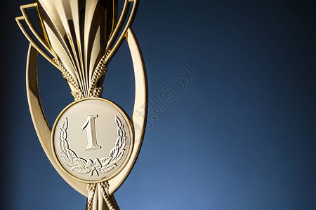 金锦标冠军奖杯或子放在蓝色背景和复图片