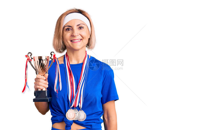 年轻的金发女子捧着冠军奖杯图片