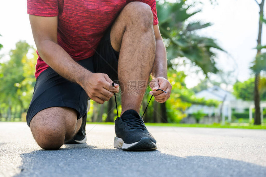 跑步的男子系鞋带健身和运动的健康图片