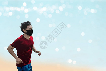 年轻的亚洲健壮青年男子穿着保护面罩COVID19跑步和运动图片