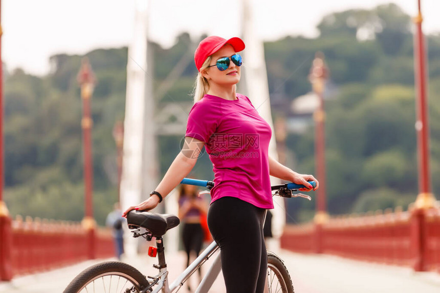 骑着自行车的年轻女子站在路图片