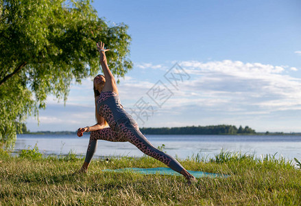 一位身材苗条金发长的女子在河岸上做瑜伽图片