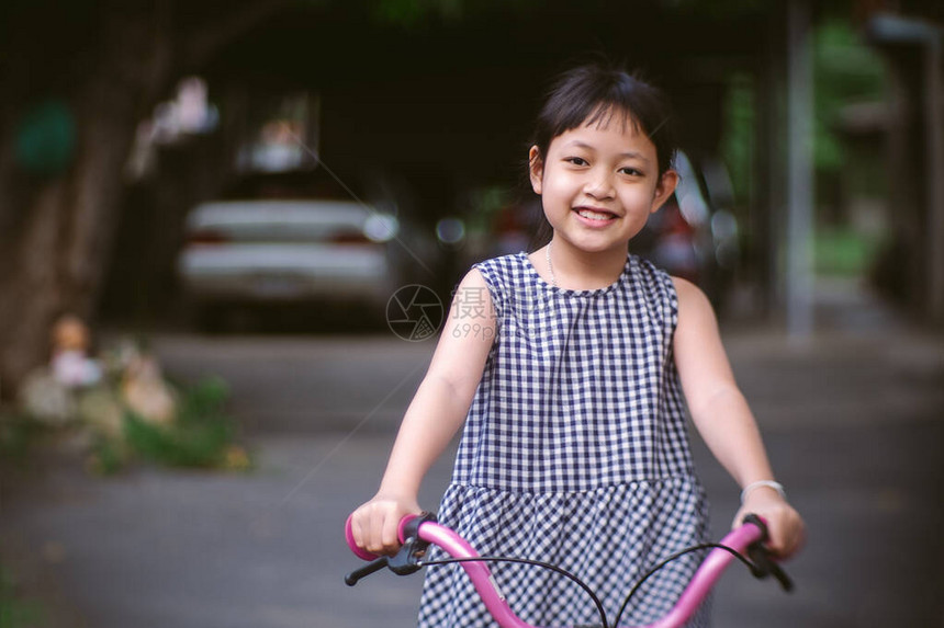 亚裔女孩带着微笑和快乐的笑容骑着自图片