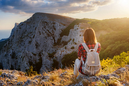 女子徒步旅行者欣赏日落山峰悬崖的景色生态旅游的想法发现旅图片