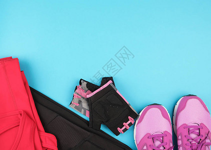 粉红妇女运动鞋和运动服装蓝底顶视复图片