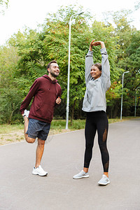 在自然绿公园里做户外伸展锻炼的年轻女和男运动健壮正面形象图片