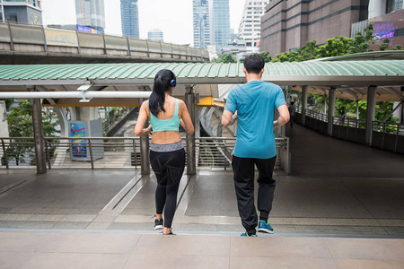 亚洲夫妇在现代城市慢跑楼下的后方图片
