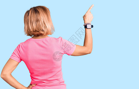 身穿运动服的金发年轻女子用手指向前图片