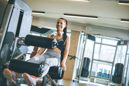在健身房运动腿伸展和腿卷曲机锻炼的图片