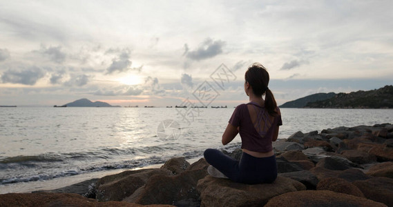 女人做瑜伽坐在海边图片