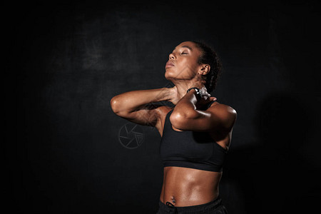自信体贴的非洲年轻健身女子在做伸展锻炼时图片