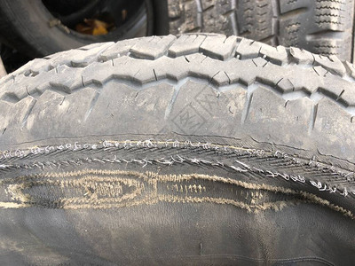 旧汽车轮胎上的洞乘用车磨损的轮胎旧车轮垃圾场图片