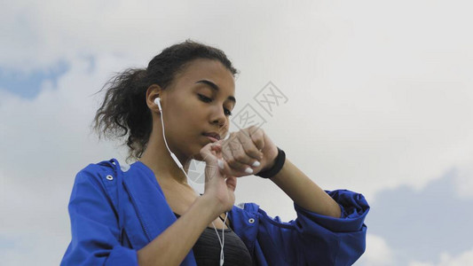 在PHOTO慢跑前使用健身手镯戴耳机的非洲裔图片