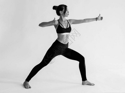 白种人黑发美丽开朗的女人做瑜伽体式的单色肖像健康的生活方背景图片