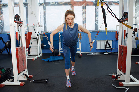 年轻美女在健身房的模拟器做体操锻炼身体建设健康的生活图片