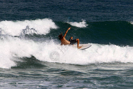 运动员在一块特殊的板上沿着海浪的波峰滑行以色列海岸附近背景图片
