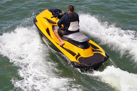 在一辆明亮的黄色喷气式滑雪艇上一位乘着佛罗里达海岸图片