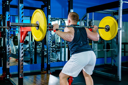 运动员在健身房的称重机旁边做背景图片