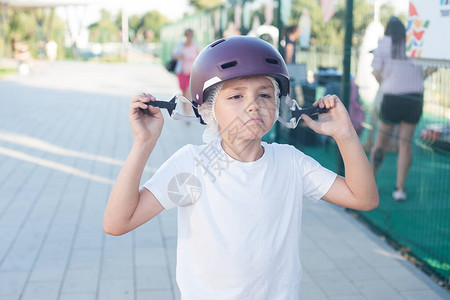 一个脸色严肃的男孩戴上防护头盔安全娱乐图片