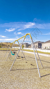 垂直框架A型框架在小型儿童游乐场中摆动在住宅之间有围墙的草地公园的小型儿童游乐场中图片