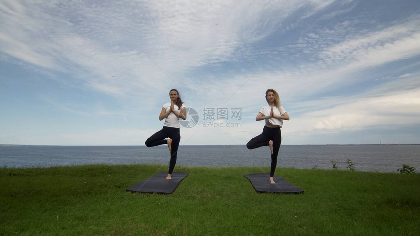 两名女在积极穿衣上练瑜伽图片