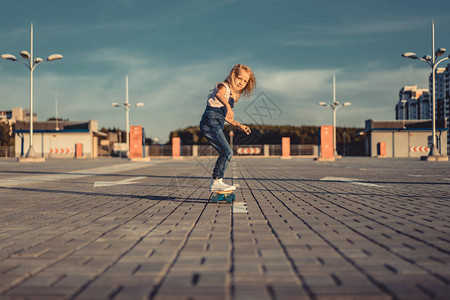 在停车场滑板上骑滑板的小孩背景图片