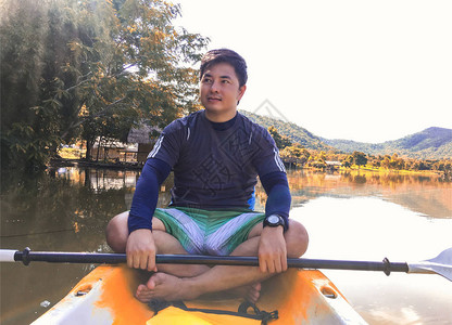 年轻人坐在皮划艇的河上图片