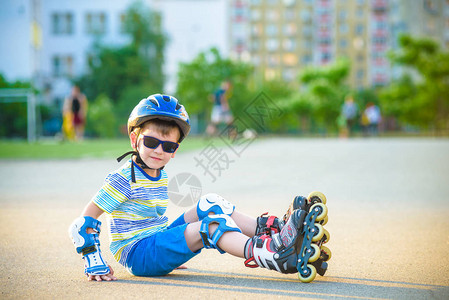 戴着保护头盔和轮滑保护垫的快乐男孩图片