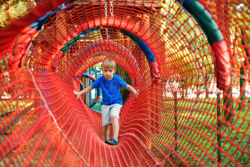 可爱的小男孩克服了户外绳索隧道中的障碍现代儿童游乐园健康的童年适合家庭的户外活动孩子在绳索冒险图片