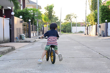 可爱男孩在街上骑平衡的自图片