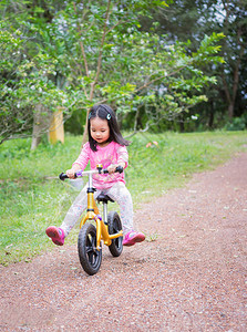小女孩学会骑平衡的自行车在背景图片