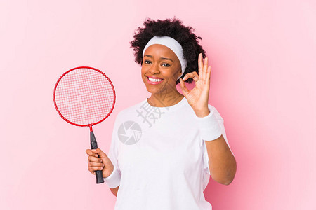 玩羽毛球的非裔美国年轻女子孤立地欢乐自信地表现图片