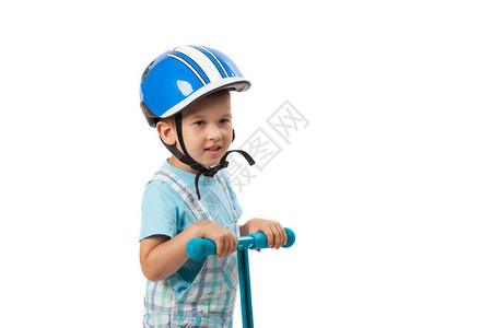 带着头盔快乐的小男孩玩着他的摩托车在图片