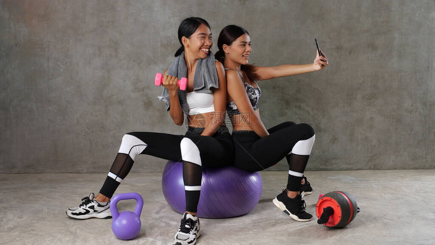 两位美丽的年轻亚洲女在健身馆拍自相照时图片