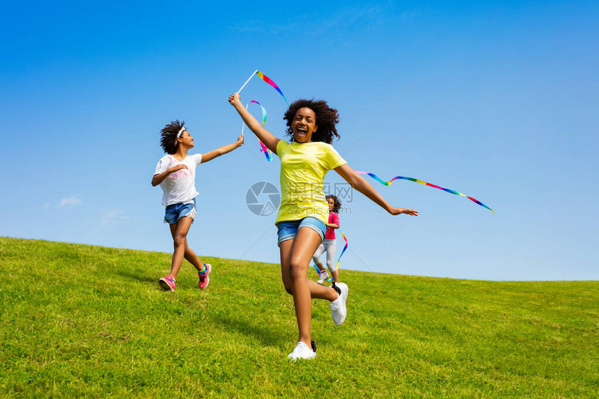 快乐地尖叫着微笑着着的非洲女孩在田野上带着图片
