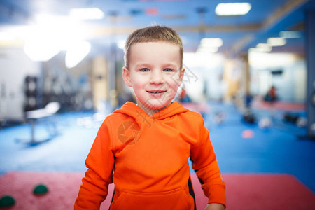 一个孩子在健身房里摆姿势的画像主题是儿童的身体发育一个穿着运动服的运动员男孩正在看着镜头背景图片