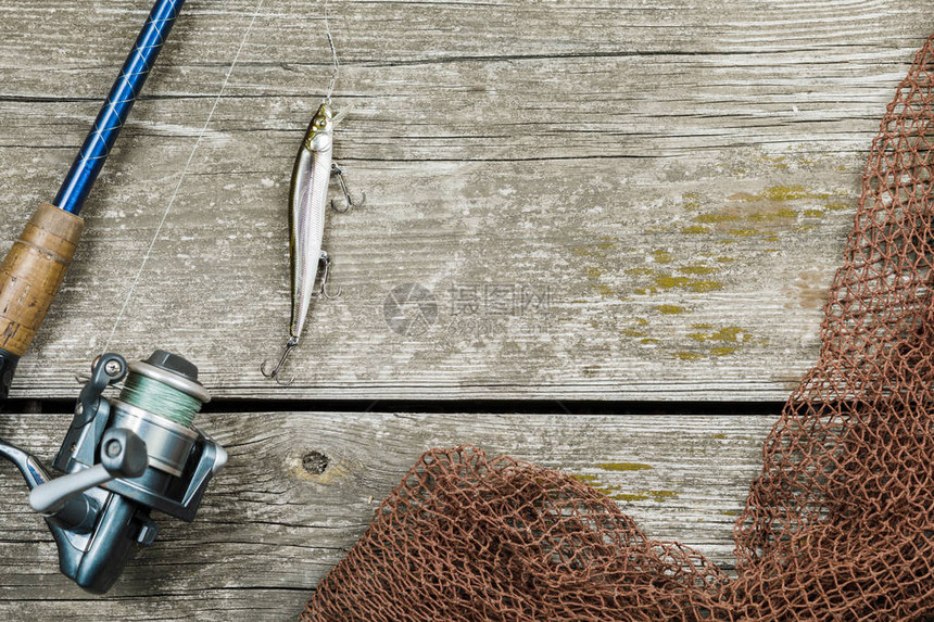 木制背景上的渔具鱼钩和诱饵图片
