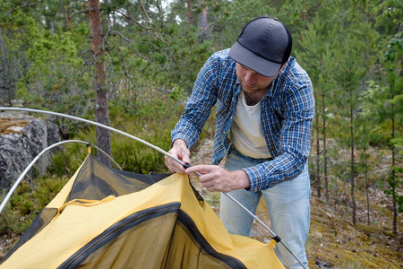 在森林营地做帐篷的男旅游图片