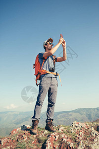 背着包在山上徒步旅行的男游客图片