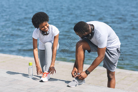 非裔男人和女人穿鞋在河岸堤边图片