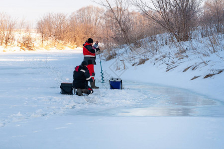 冬季捕鱼河冰上的两只角鱼正在准图片