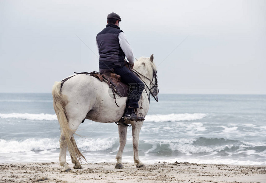 骑马的男人在海滩图片