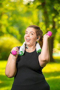 快乐的胖女人在公园里做运动和哑图片