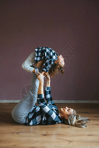 柔软的caucasiansian妇女与儿一起做杂技锻炼图片